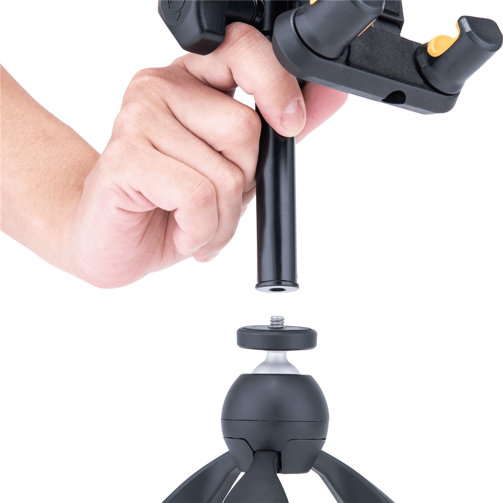 Close-up of a hand assembling a camera tripod head, inserting a black post into the ball joint above the tripod head.